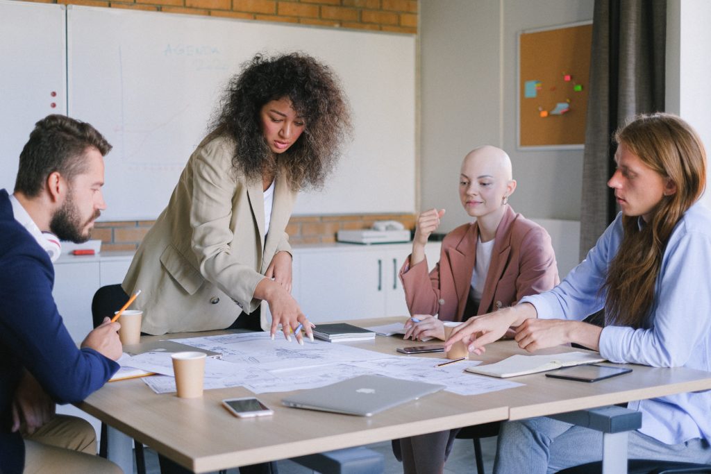  A group of four people working around a square table.